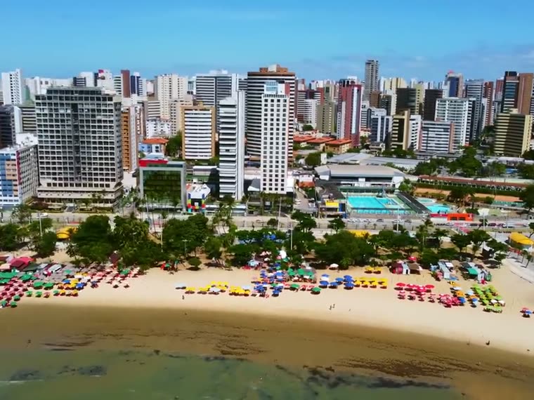 Praia de Iracema com barracas coloridas e a cidade ao fundo